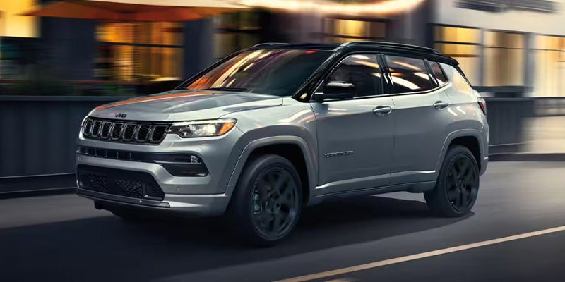 a silver 2025 Jeep Compass driving down a highway