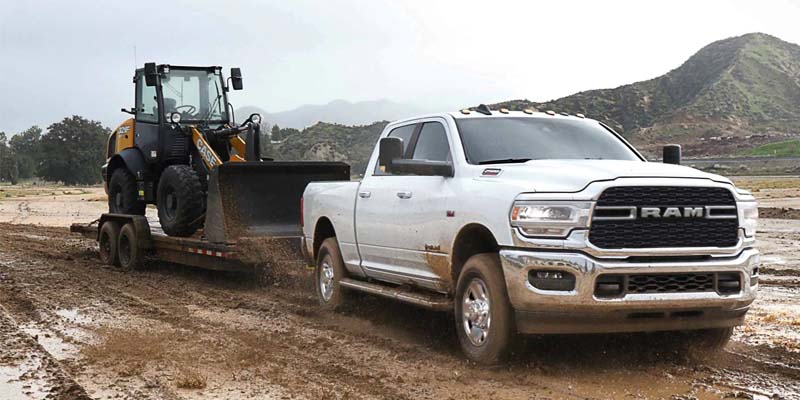 a white 2024 RAM 2500 driving down a dirt road
